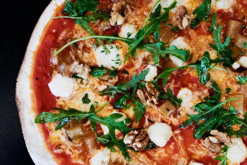 Pizzakreation »Der süße Bock« mit Bio-Ziegenbrie, Birnen-Chutney, Rucola, Walnüssen, Thymian und Tomantensauce.