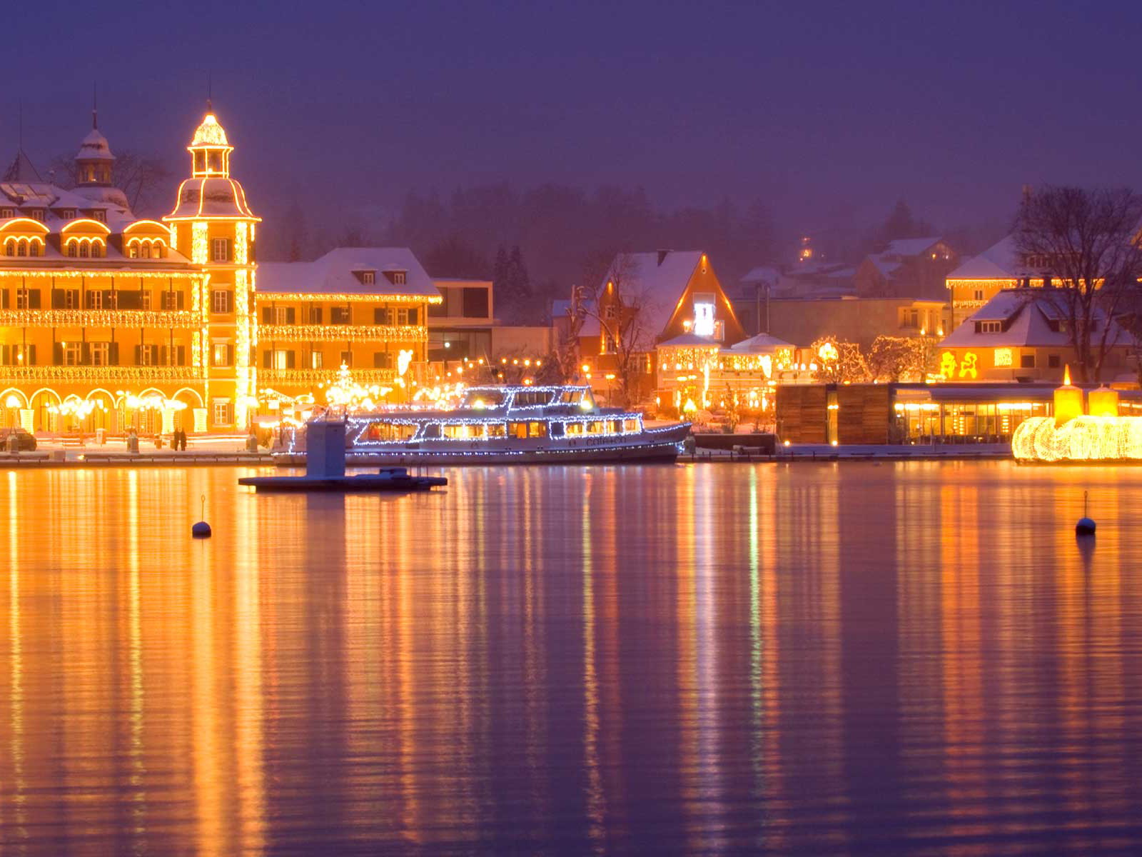 Das weihnachtliche Schloss Velden mit dem schwimmenden Adventskranz am Wörthersee.