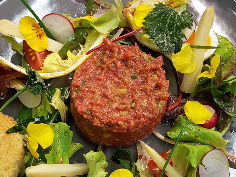 Lamm-Tatar im «Kornplatz» mit eingelegten Spargeln, wachsweichem Wachtelei und Rosmarin-Toast.