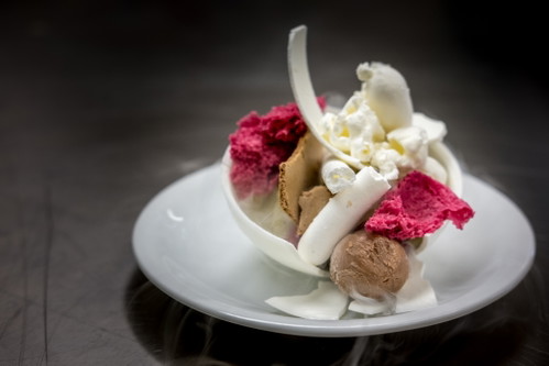 Ein Dessert mit sieben Komponenten: Grüntee-Yuzu-Pudding, Meringue aus scharfem Senf und Yuzu, Himbeergel, getrocknetes Schokoladenmousse, gefrorene Himbeer-Yuzu-Luft, Rote Beete-Sponge, helles und dunkles Schokolade-Popcorn.