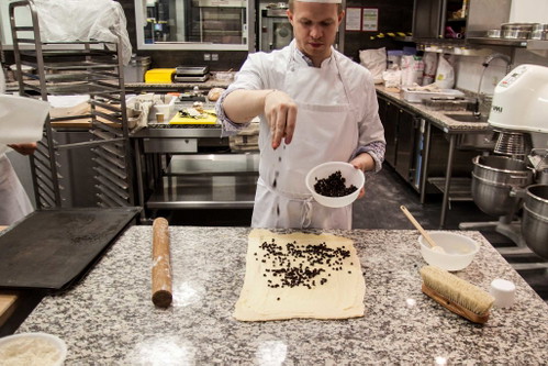 Pain aux raisins mit Rosinen bestreuen.