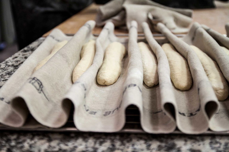 Das Baguette ruht nach dem Formen im Bäckerleinen. 