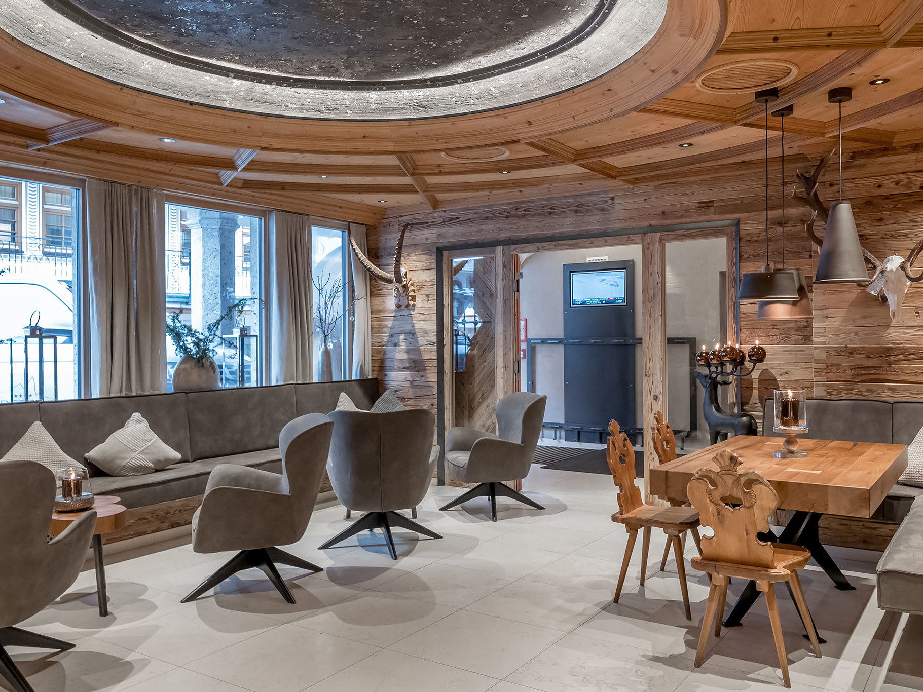 Die modern-rustikale Rezeption und Lounge des Vier-Sterne Hotels lädt zum Verweilen ein.