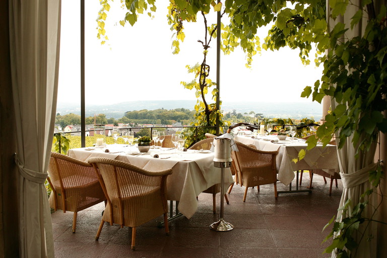 Die Terrasse des Burgrestaurants ist von Weinreben umrankt.