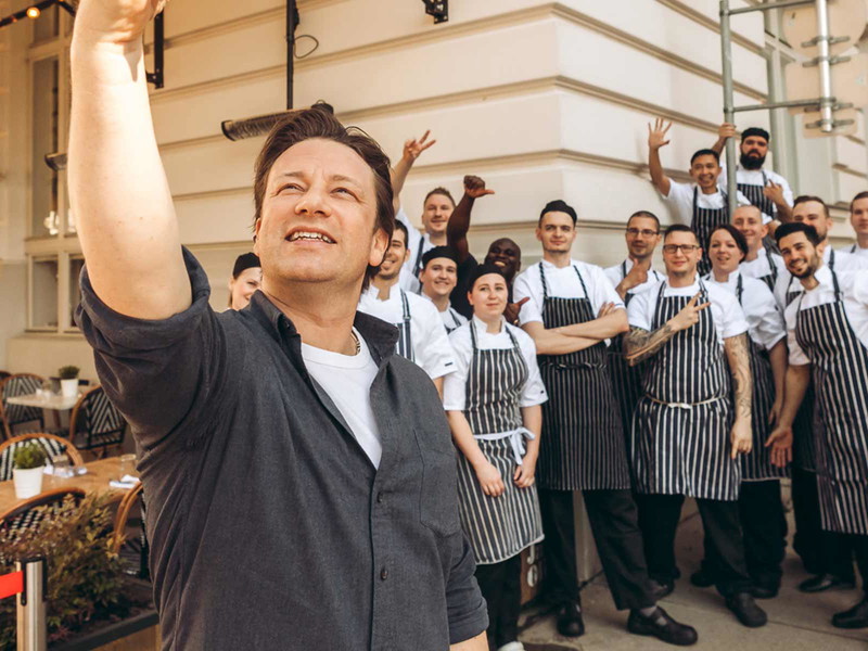 Jamie Oliver mit seinen Mitarbeiter:innen vor seinem ehemaligen Wiener Lokal.