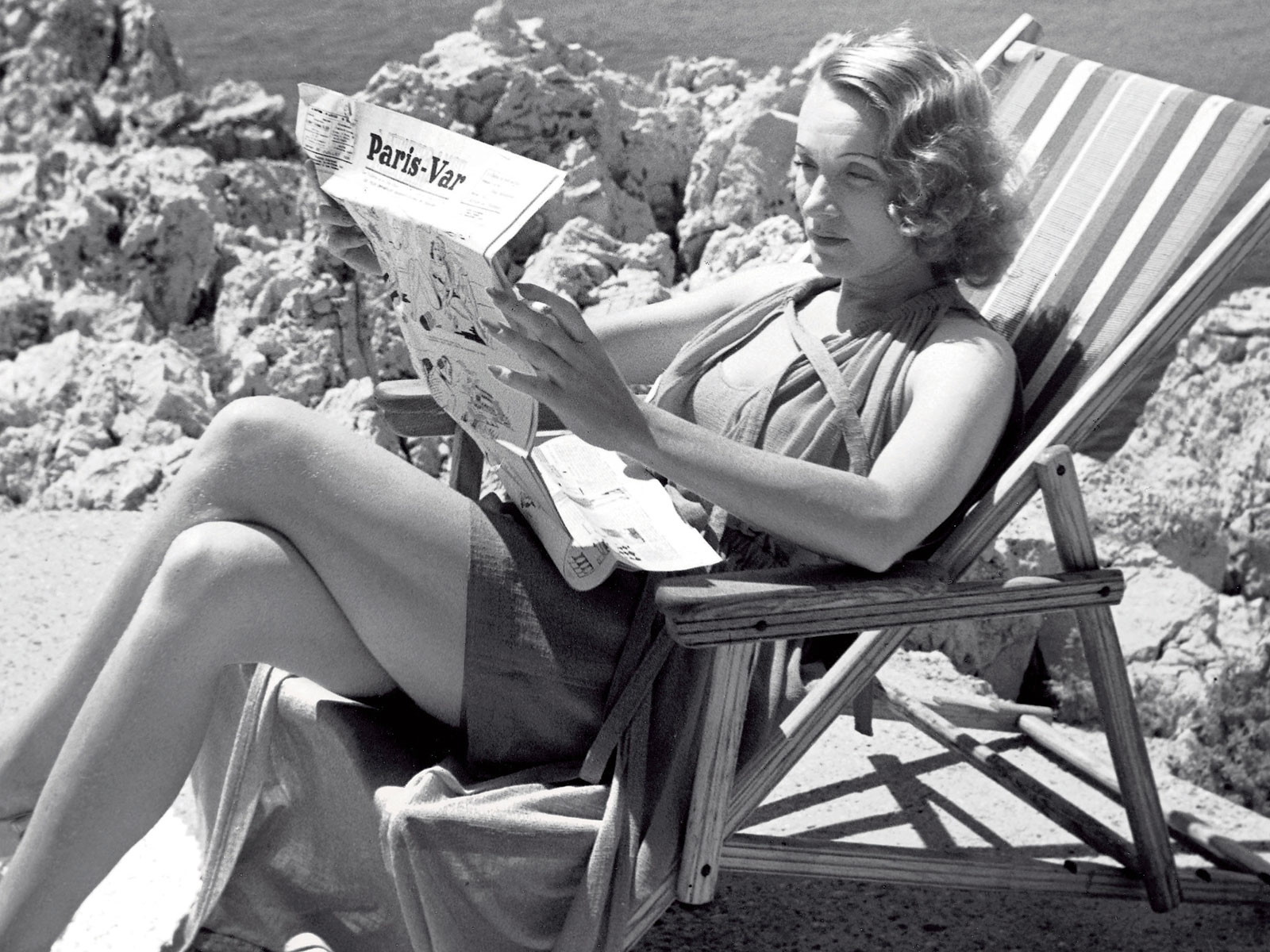 Marlene Dietrich bei der Lektüre des »Paris-Var« am Strand des »Eden-Roc«.