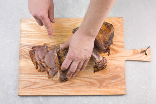 Sobald der Knochen ausgelöst ist, das Fleisch quer zur Hauptfaser in gleichmäßige Stücke schneiden.