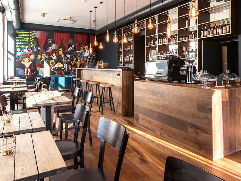 Das Kunstwerk am Ende des Raumes ist das bestimmende Element der Café-Bar.