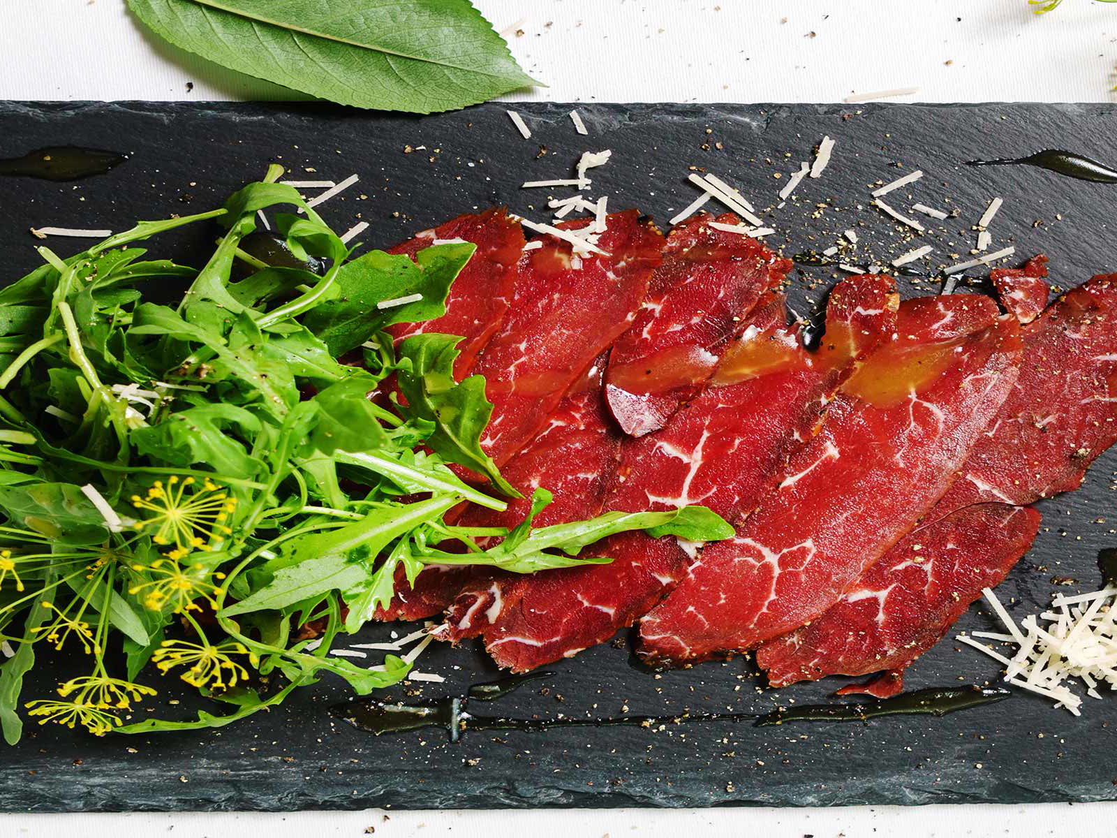 Carpaccio vom Rind garniert mit Rucola und Parmesan.