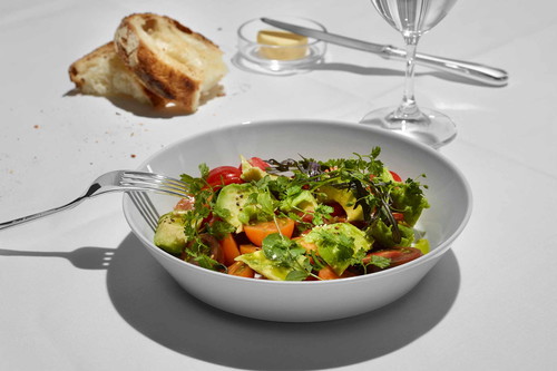 Grüner Salat mit Avocado, Tomaten, Eiern und Speck.