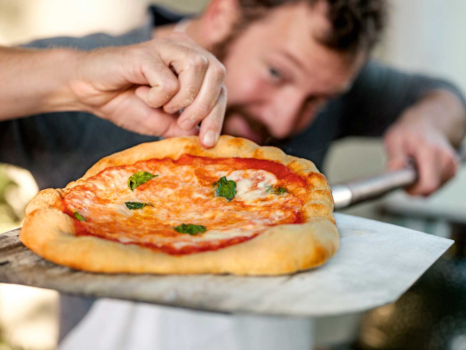 Ist sie unten auch nicht ­angebrannt? Der Blick auf den Pizzaboden gehört zur ­Qualitätskontrolle des­ ambitionierten Balkon-Pizzaiolo.