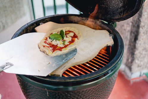 Mit Gefühl von der Schaufel auf den SteinDie Pizza von der Schaufel auf den Pizzastein zu befördern, kann etwas herausfordernd sein: Arbeiten Sie mit Gefühl und ruckartigen Bewegungen, und helfen Sie mit den Fingern etwas nach, falls die Pizza nicht auf den Stein will.