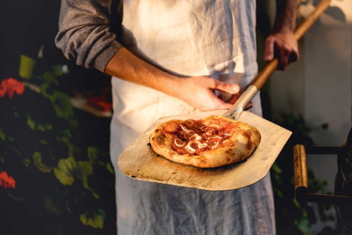 Heiß, aber nicht ­brennheiß backenUm die 300 Grad sollte Ihr Griller schon haben, damit das was wird mit dem perfekten Teig. Achten Sie aber darauf, dass der Pizzastein nicht zu heiß wird und den Boden verbrennt. Ein Hitzeschild oder Glut nur am Rand helfen.