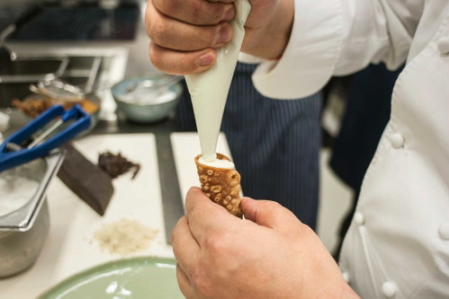 Die Cannoli werden mit der Ricotta-Creme gefüllt.
