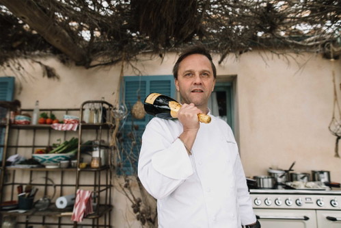 Der Spitzenkoch Robin Zavou mit einer Flasche KRUG.