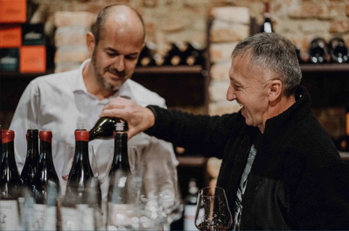 Karl Schnabel schenkt Christian Edelsbrunner Wein ein.