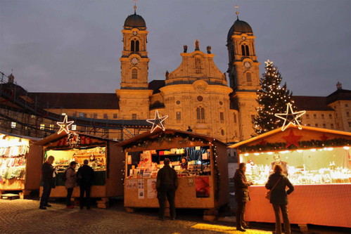 Weihnachtsmarkt Einsiedeln Auf dem Klosterplatz steht ein grosser Weihnachtsbaum und heimelig dekorierte Verkaufsstände. Der gesamte Markt erstreckt sich vom Kloster bis zum Bahnhof.