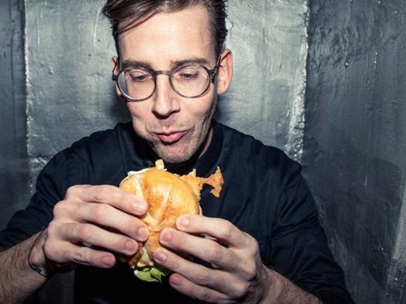 Carlo Neumann mit Schnitzelsemmel, die tatsächlich angeboten wird.
