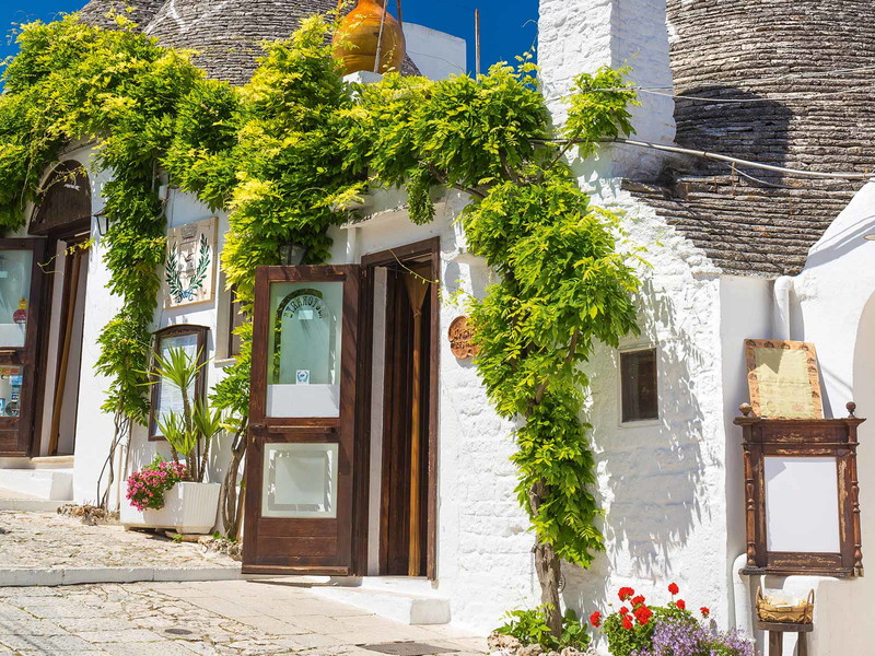 Die Trulli, Steinhäuser mit kegelförmigen Dächern, sind die Wahrzeichen von Apulien. Früher waren sie Arme-Leute-Unterkünfte, heute wohnen dort Touristen.