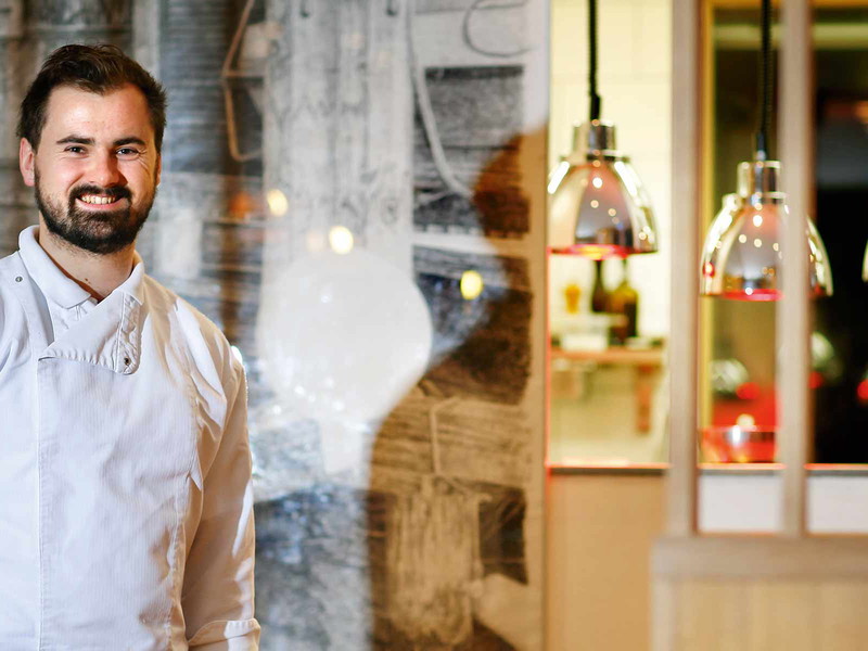 Küchenchef Lukas Nagl vor dem Küchenbereich Seehotel »Das Traunsee«