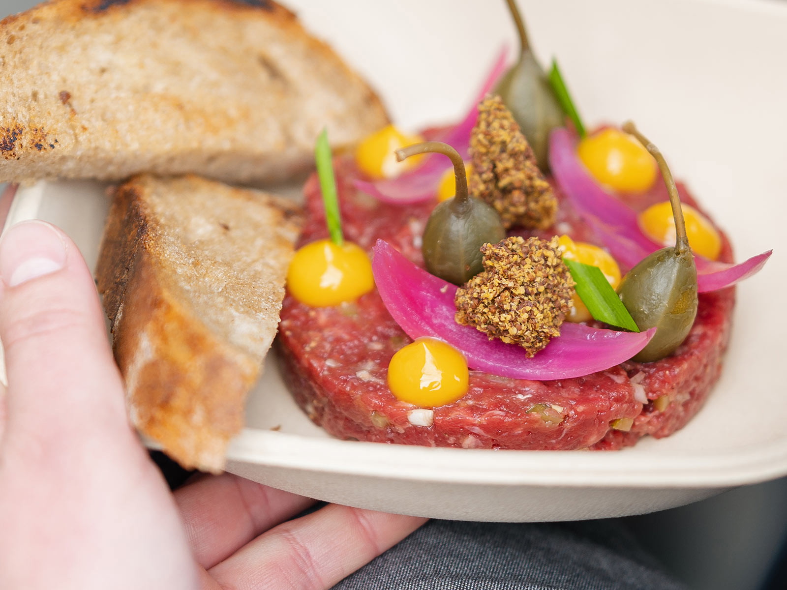 Stefan Jäckel's Tatar vom Schweizer Rind mit Eigelbcreme, Kapernäpfel, Rotweinziebeln, Senf und geröstetem Brot