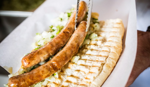 2. Darauf kommen zwei Schweinsbratwürstel, die zuvor aus Geschmacksgründen lange und mit extra viel Fett am Grill gelegen sind.