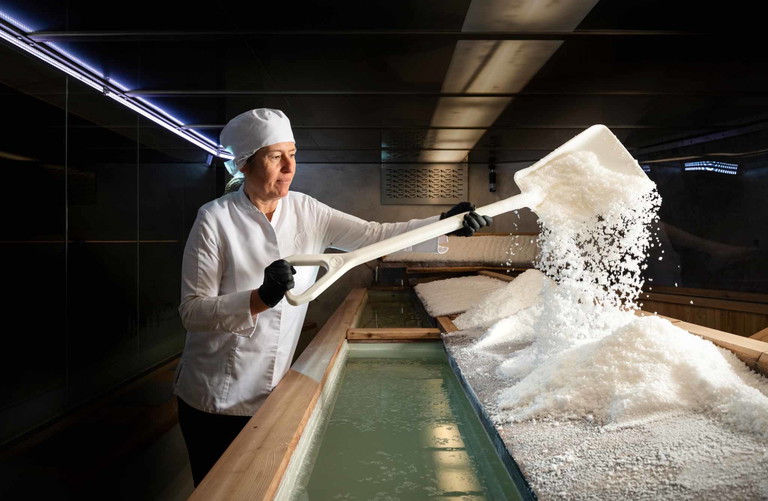 Von Hand werden die Flocken des Fleur des Alpes aus dem Wasser geschöpft. Anschliessend trocknet das Salz noch einmal auf Lärchenholz.