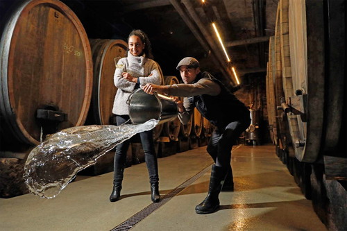 Weingut und Gutsausschank Heinrich Spindler in Forst: Markus Spindler übt sich im Wasserkunstwurf, Ehefrau Loladé hält sich an ein Glas Riesling aus Forster Lagen.