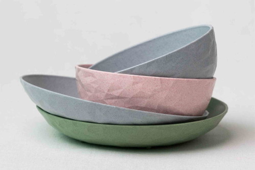 Teller und Schüsseln aus recyceltem Plastik, Holz oder Verbundstoffen.