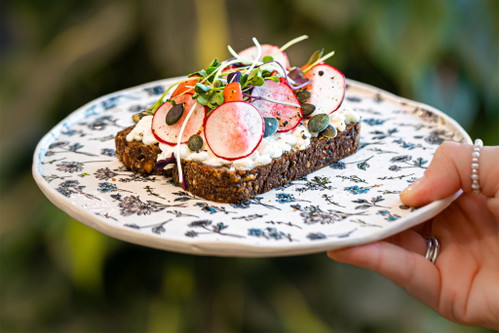 Brot mit Hüttenkäse, eingelegten Radiesli und Kürbiskernen