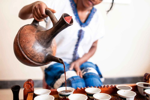 The finished coffee is then poured from the&nbsp;clay pot into the cups.