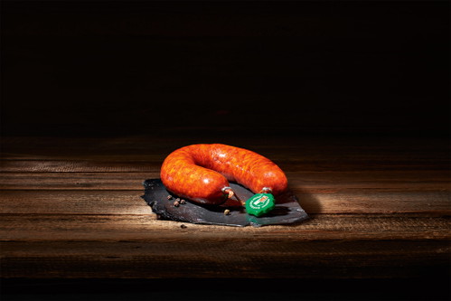 Die grüne Plombe garantiert die Herkunft der Saucissons und deren Herstellungsweise. Die hier abgebildete Saucisse aux choux beinhaltet neben Schweizer Schweinefleisch auch Kraut.