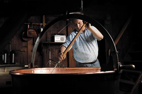 Die Käsebruch wird mit Hilfe eines «Käseharfen» in kleine Körner zerschnitten.