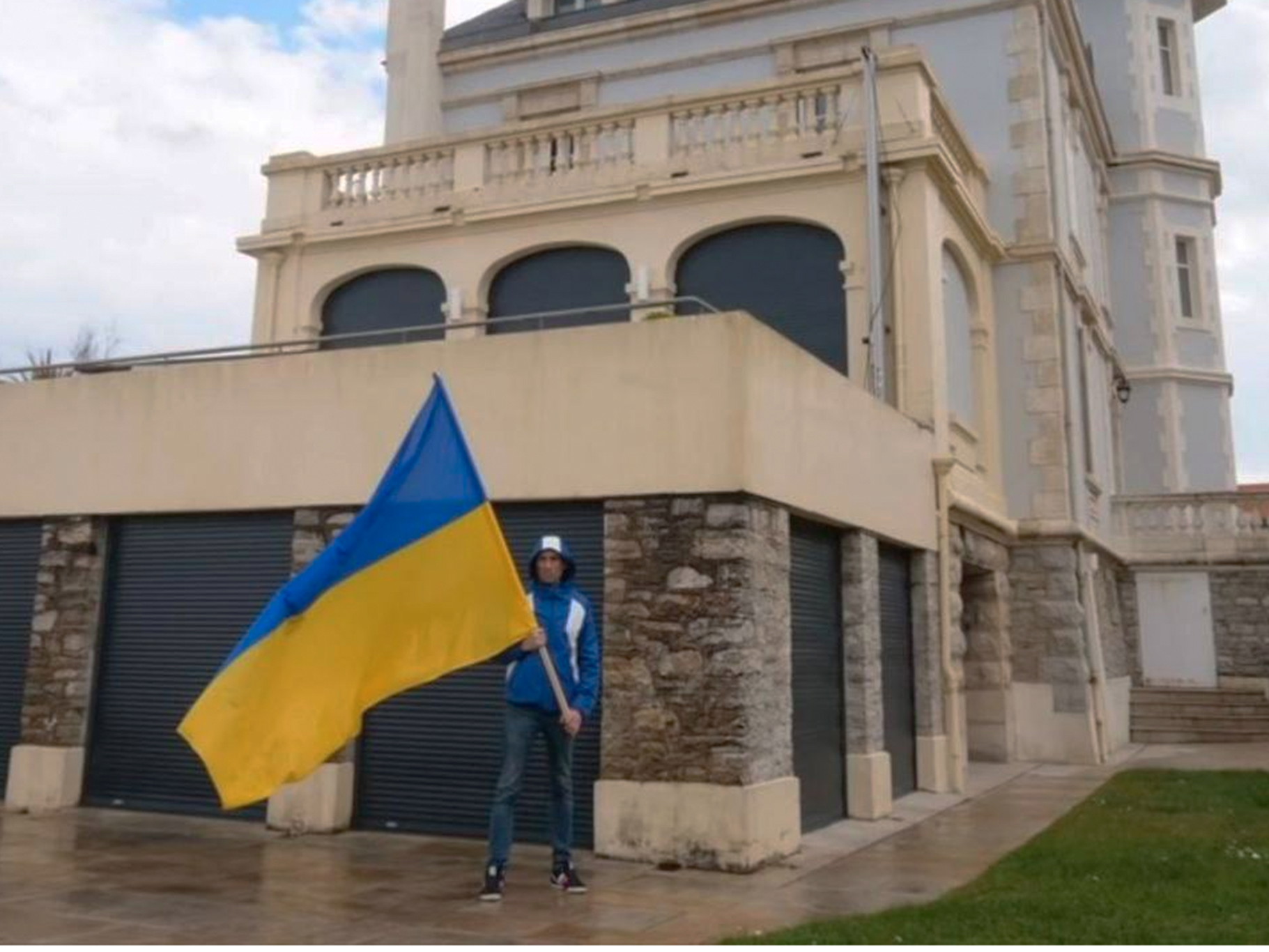 Ein Friedensaktivist schwenkt die Ukraine-Flagge vor der Villa des Oligarchen in Biarritz