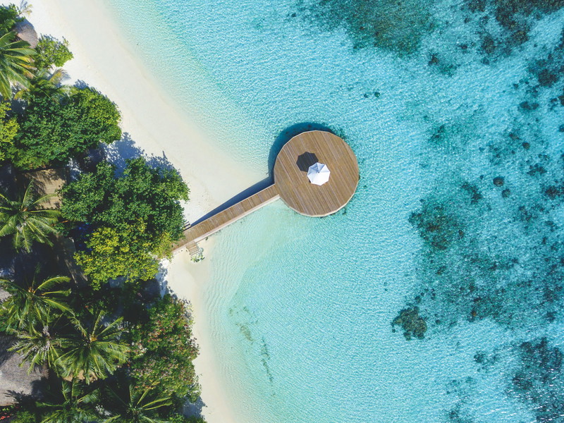 Jungle and sea flank a white sand beach at the Baros resort in the Maldives.