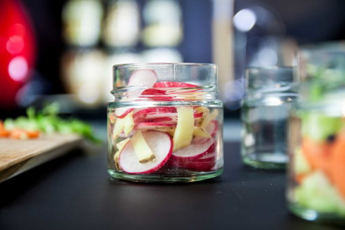 Das Gemüse, wie hier die Radieschen, werden anschließend roh in das Glas gegeben.