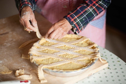 6. Das klassische Muster legen
Ohne die richtige Verzierung ist eine Pastiera keine Pastiera. Die Teigstreifen überlappend auf der Füllung verteilen. Das soll laut Legende das Straßenmuster von Neapels griechischer Altstadt repräsentieren.