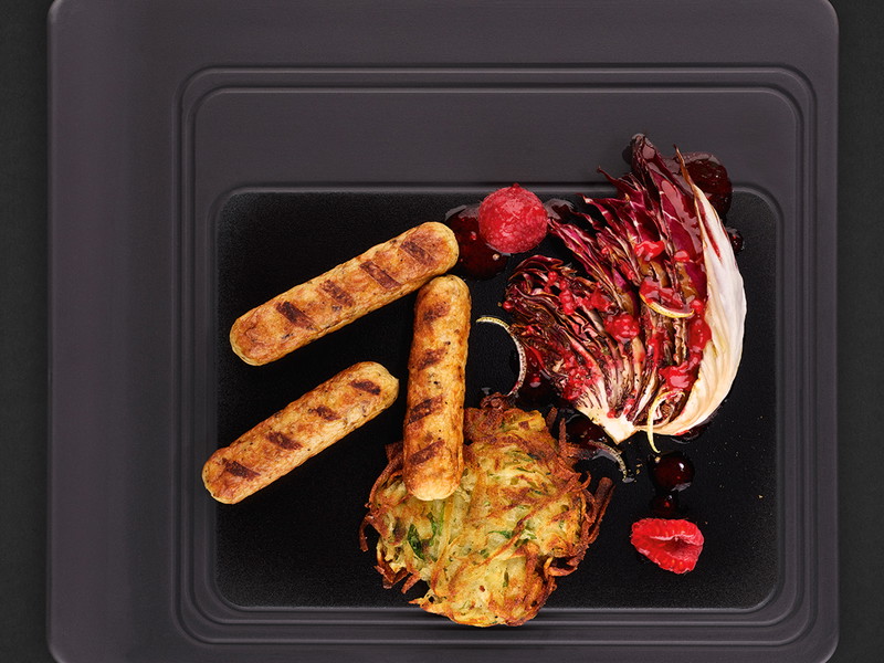 Rostbrat-Würstchen mit gegrilltem Radicchio, Kartoffelpuffer und Himbeerdressing.