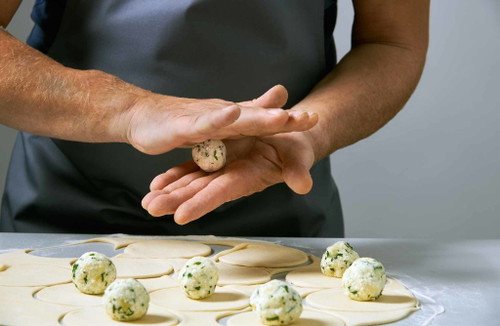 2. Aus der Fülle kleine Knödel formen und mittig auf die Teigkreise legen.