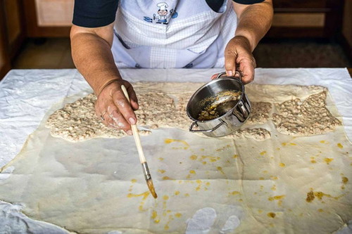 7. Fülle verteilen. Die Masse auf einer Hälfte des Teigs verteilen, die andere Hälfte mit heißer Butter beträufeln.