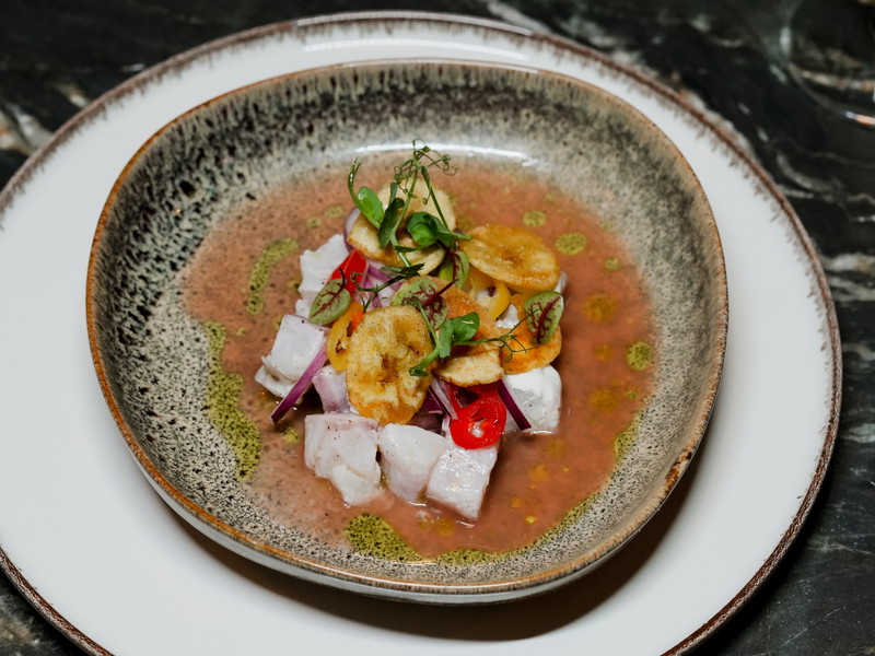 Zur Ceviche mit Wolfsbarsch, Leche de Tigre, kandierter Chili, Süßkartoffel und Bananenchips trinkt man am besten einen Wermut-Cocktail