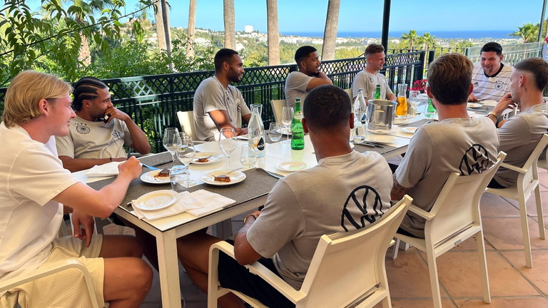 Tim Mälzer (2. v.r.) mit den Nationalspielern v.l.: Julian Brandt, Serge Gnabry, Jonathan Tah, Benjamin Henrichs, Lukas Nmecha, Joshua Kimmich, Kevin Trapp und David Raum in Marbella, Spanien.