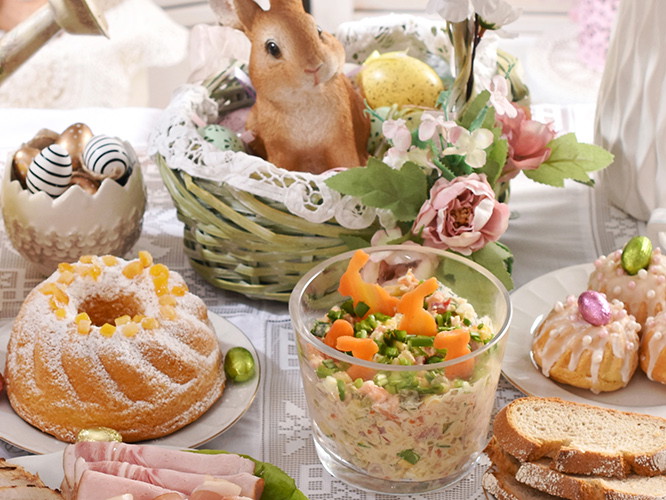 traditional Easter dishes with white borscht, sausage, eggs, salad and cakes on festive table in Poland