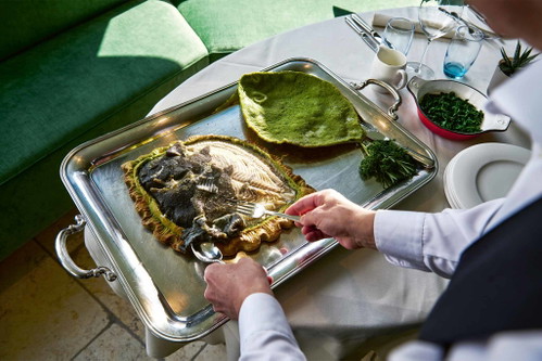 Ganzer Steinbutt in der Salzkruste mit Spinat.