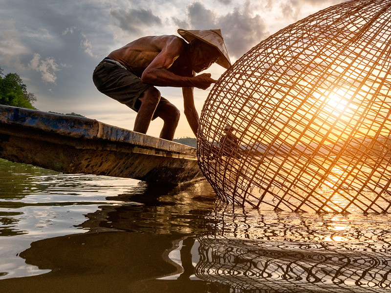 Ein kambodschanischer Fischer mit einer traditionellen Reuse im Mekong-Delta. Der mehr als 4000 Kilometer lange Fluss ist die Lebensader Indochinas und versorgt Millionen Menschen mit Nahrung und Wasser.