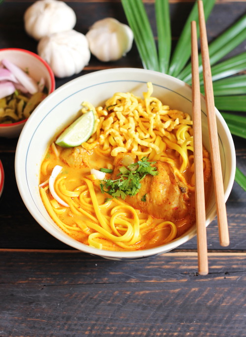 Khao Soi ist eine würzige Kokos-Curry-Suppe mit Huhn und Weizennudeln, die in Laos und im Norden Thailands gerne gegessen wird.