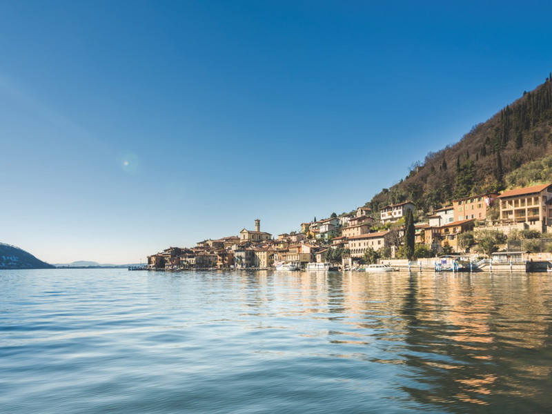 Hier kann man die Seele baumeln lassen. Der Iseosee ist noch beschaulich, der Gästestrom überschaubar. Den Besucher erwarten feine Franciacorta und köstliches Essen. 