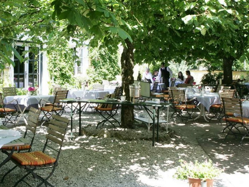 Im Innenhof des Schloss Aigen spendet ein alter Baumbestand Schatten.