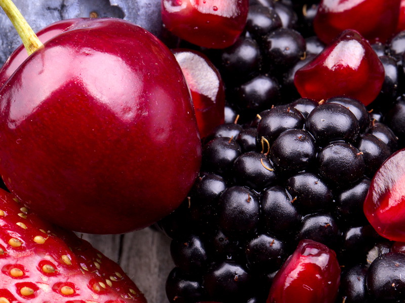 tasty summer fruits on a wooden table. Cherry, Blue berries,  strawberry, raspberries, Blackberries, pomegranate