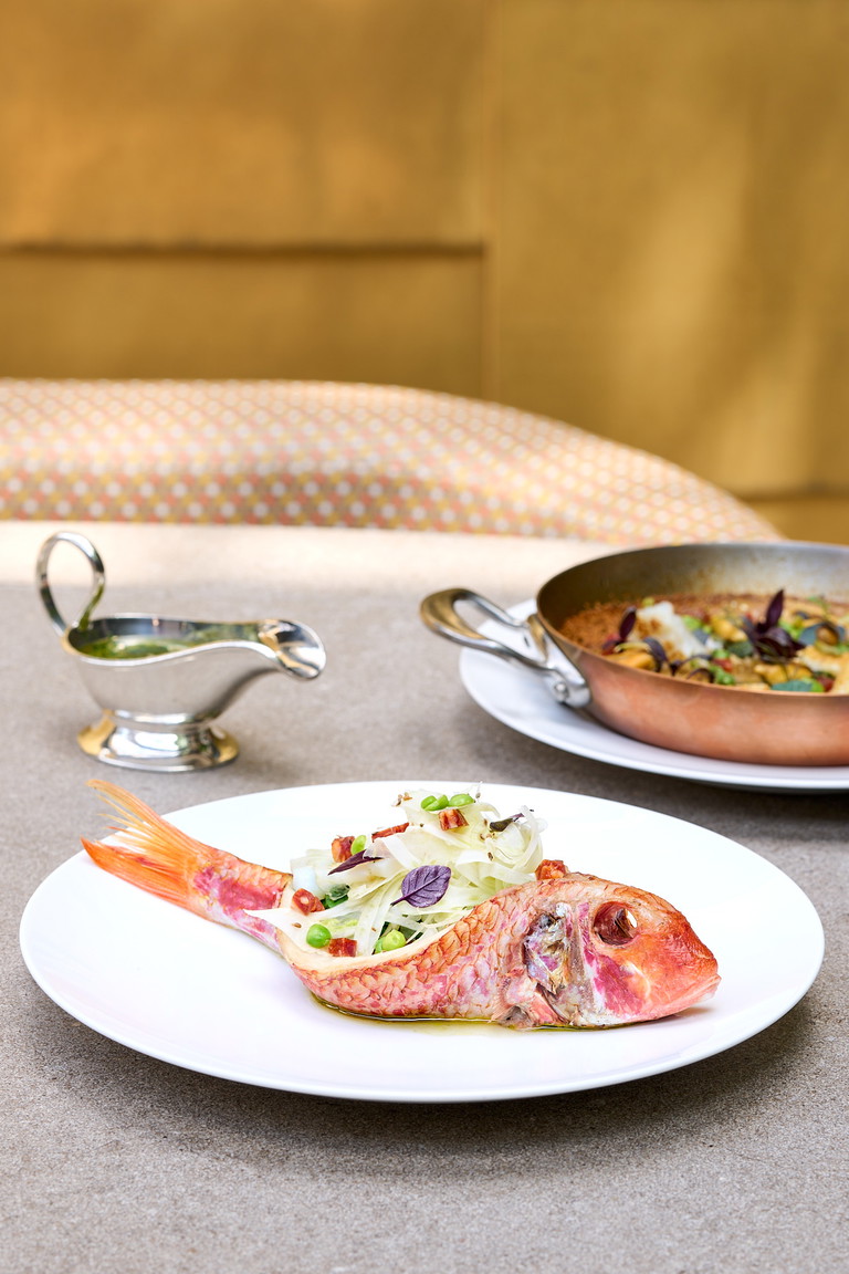 Sie »Rouget de Roche farci à la méditerranéenne« (Felsenrotbarbe), mit einer mediterranen Vinaigrette und einer Kupferpfanne karamellisiertem Reis sowie frischem Fenchelsalat.